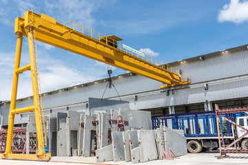 Precast concrete panels arranged beneath a yellow gantry crane