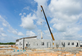 Crane operating beside a precast building under construction