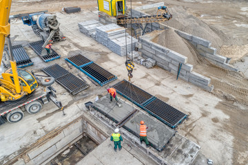Construction team coordinating precast elements and reinforcement at an active site